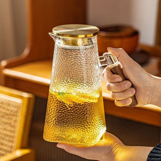 Pichet en verre borosilicaté avec poignée en laiton, élégant et résistant à la chaleur.