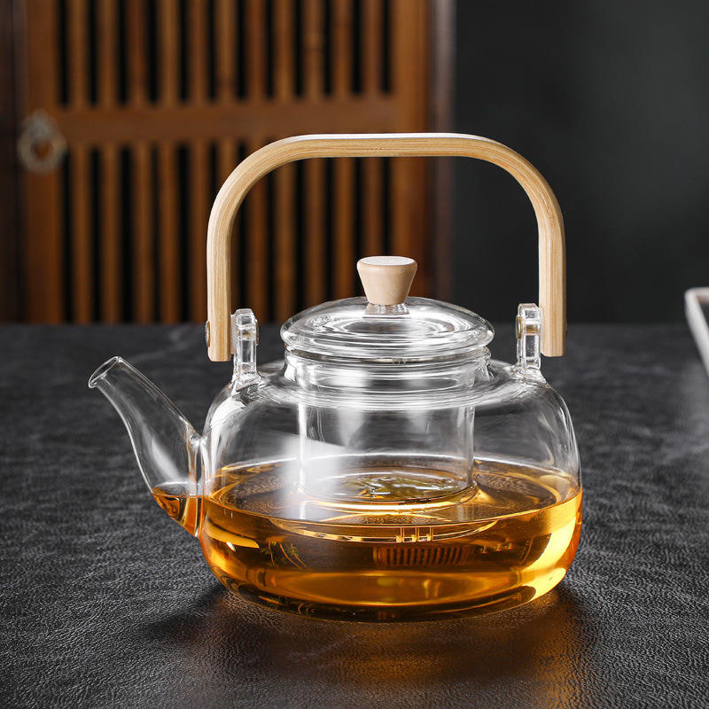 Théière en verre pour cuisinière avec poignée en bambou et filtre infuseur intégré pour une infusion parfaite du thé.